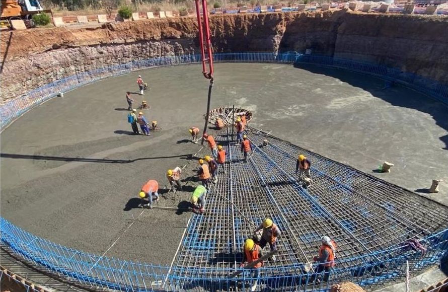 Concrete pour with site crew in a circular excavation